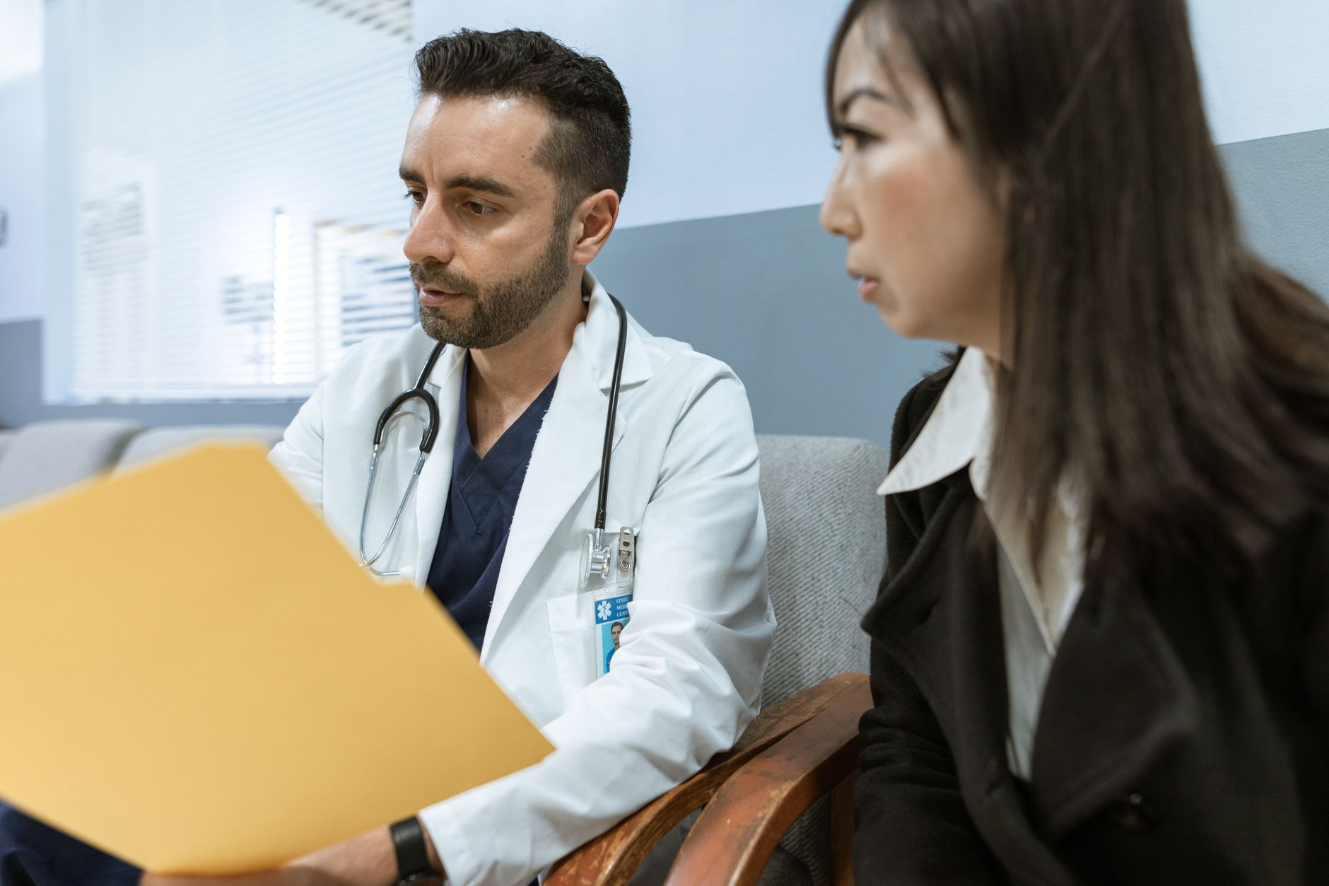 Médecin et patiente échangeant lors d'une consultation, dossier médical en main