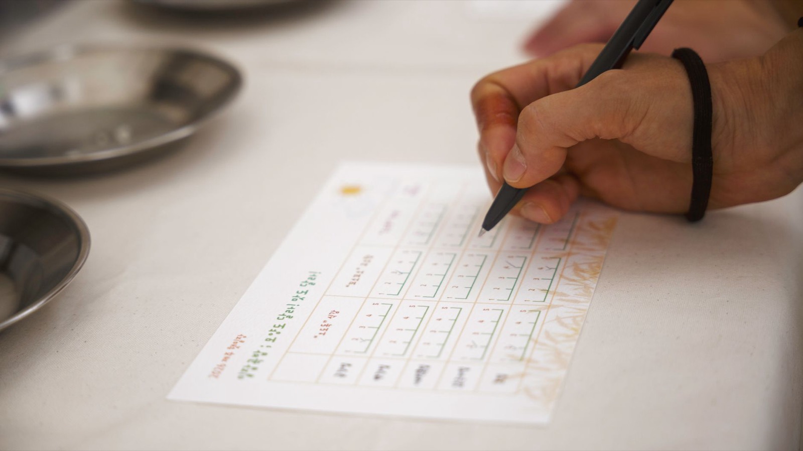 Personne remplissant un formulaire papier sur une table